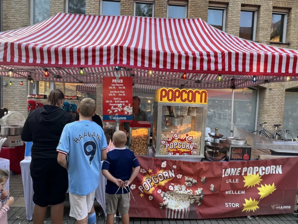 Børn i kø ved popcornboden med rød-hvidt telt til byfest i Allerød