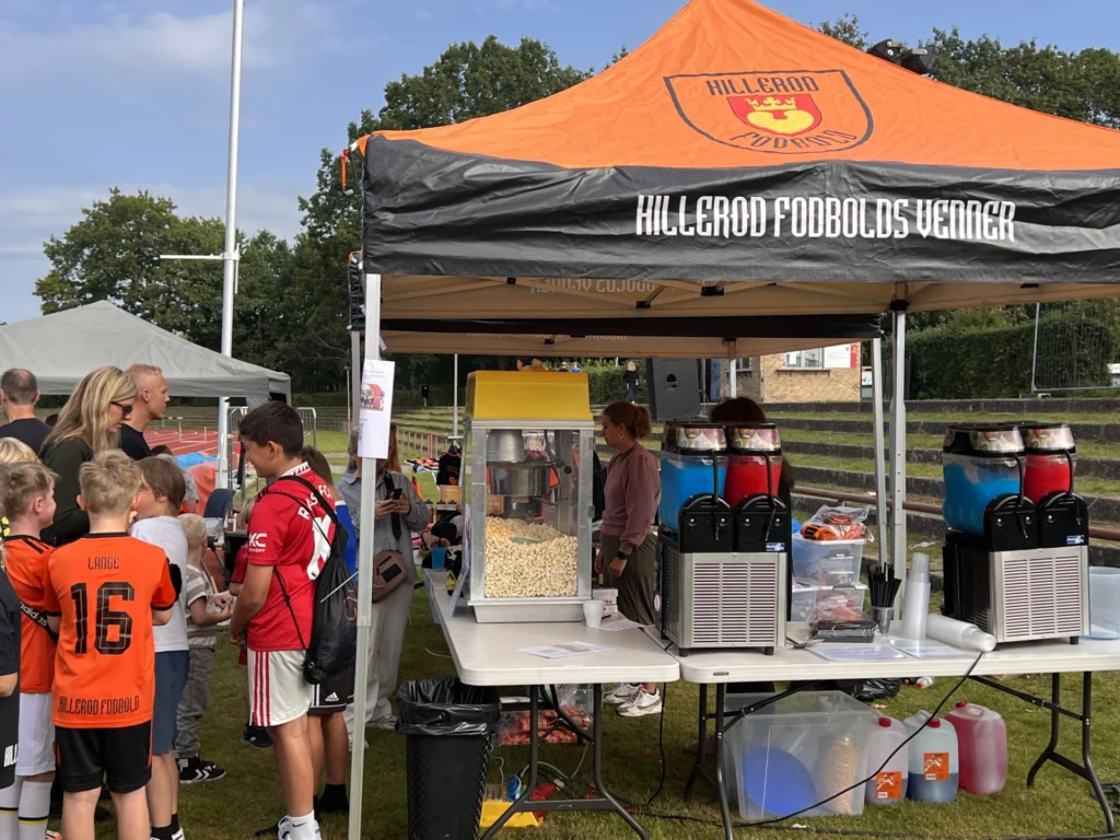 Børn i kø ved popcorn- og slush ice-boden til Hillerød Fodbolds familiedag