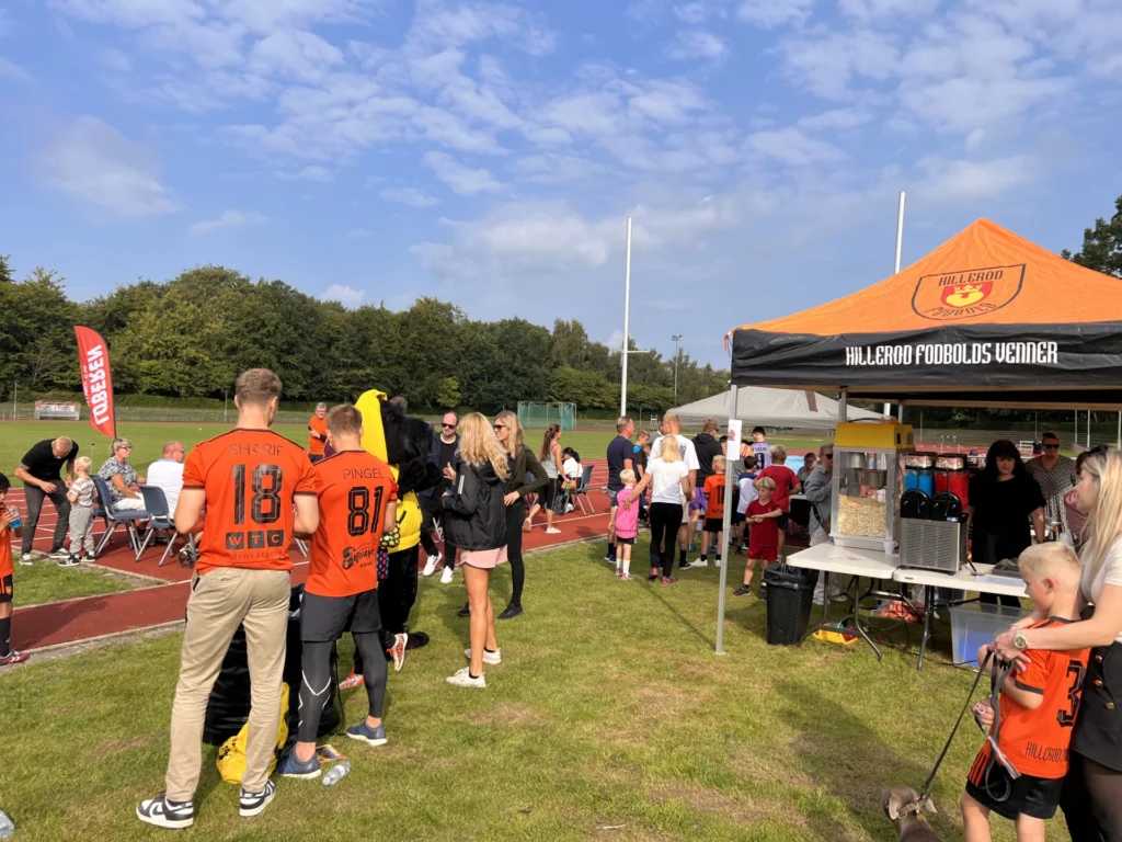 Spillere og familier ved popcorn- og slush ice-teltet til Hillerød Fodbolds familiedag