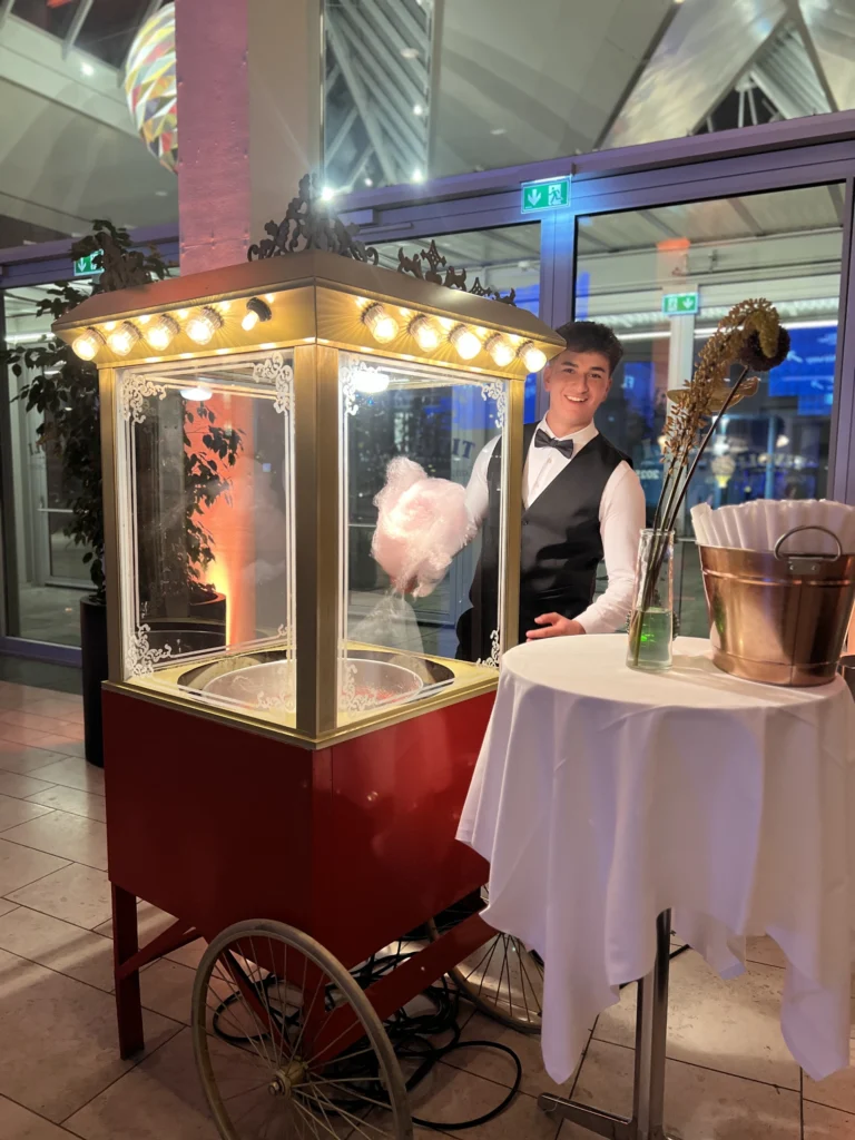 Tjener laver candyfloss i guldfarvet candyflossvogn til gallafest på Tivoli Hotel & Congress Center